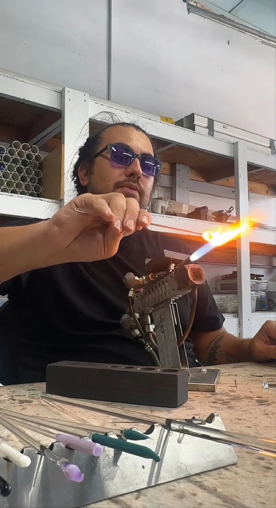 Tino shaping glass with a torch at the bench